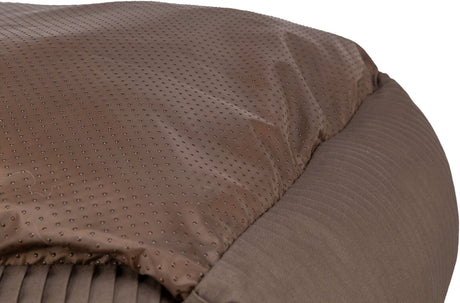 Ein braunes Kissen mit gepunktetem und geripptem Stoff, das eine weiche Oberfläche zeigt.