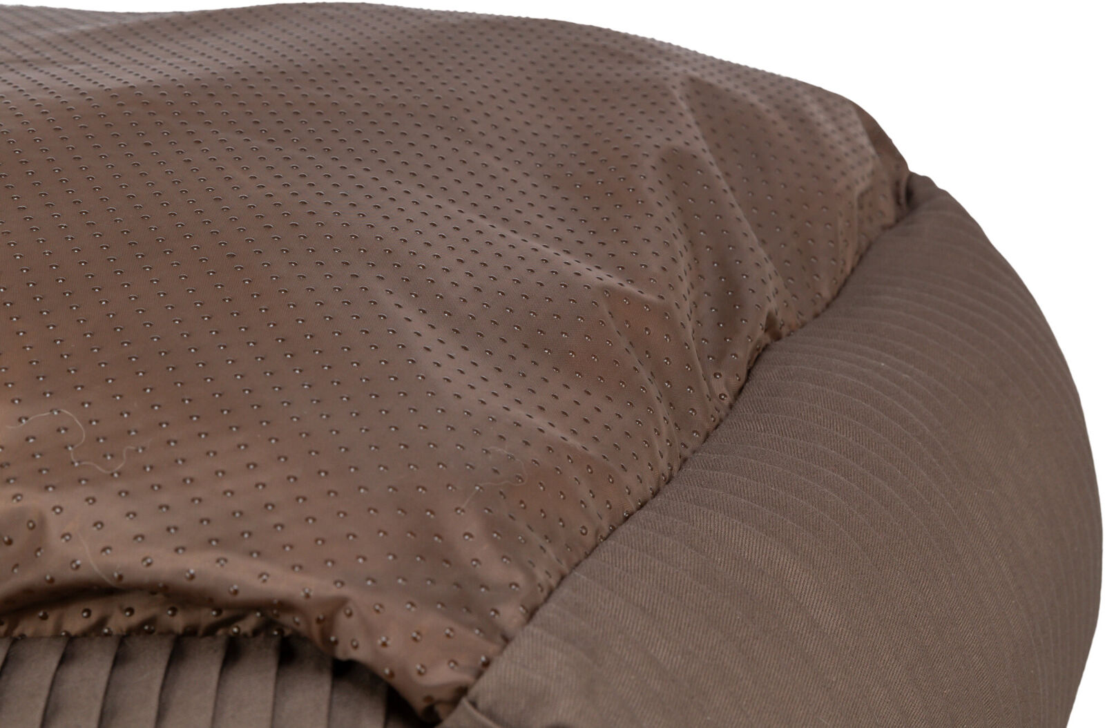 Ein braunes Kissen mit gepunktetem und geripptem Stoff, das eine weiche Oberfläche zeigt.