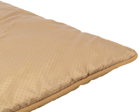 Beigefarbenes, dick gepolstertes Kissen mit kleinen, gleichmäßigen Punkten auf der Oberfläche.