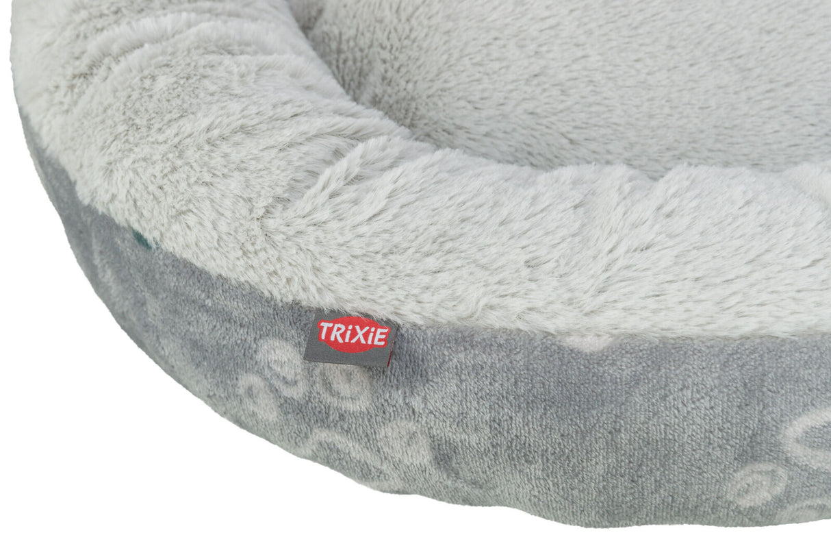 Graues, rundes Bett mit flauschigem Rand, sichtbarer Text "TRIXIE" auf rotem Etikett.