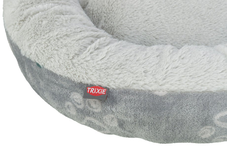 Graues, rundes Bett mit flauschigem Rand, sichtbarer Text "TRIXIE" auf rotem Etikett.