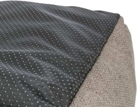 Grau gepunktetes, schwarzes Textilmaterial neben grob gewebtem, beigem Stoff.