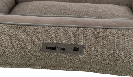 Beiges Textilbett mit rechteckigem Label "homeEdition TRIXIE" auf der Front.