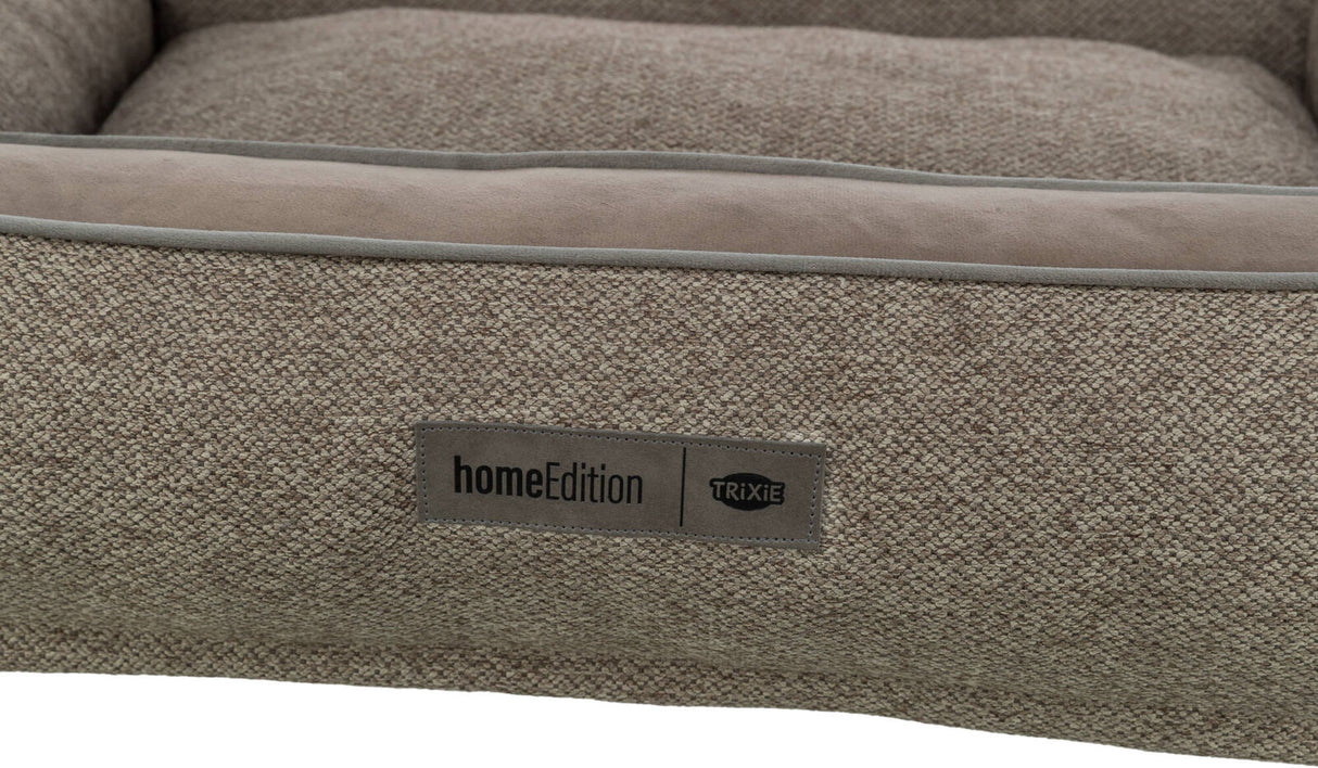 Beiges Textilbett mit rechteckigem Label "homeEdition TRIXIE" auf der Front.