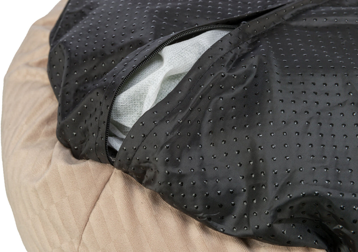 Schwarzes, gepunktetes Material mit Reißverschluss über beige Textur, darunter weißes Füllmaterial sichtbar.