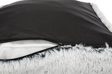 Schwarzes, gepunktetes Material mit Reißverschluss und grauem, flauschigem Rand, teilweise geöffnet.