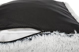Schwarzes, gepunktetes Material mit Reißverschluss und grauem, flauschigem Rand, teilweise geöffnet.
