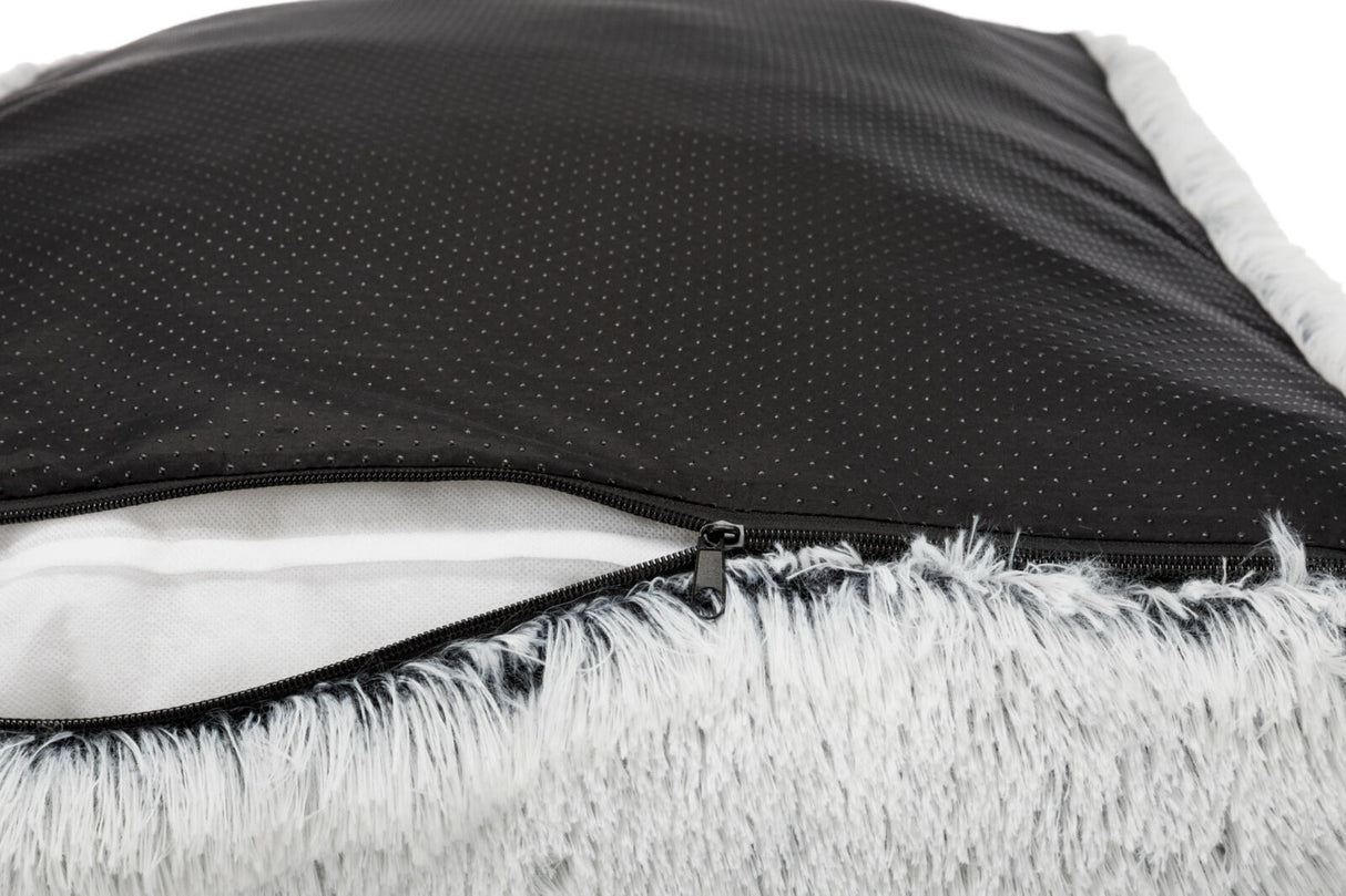 Schwarzes, gepunktetes Material mit Reißverschluss und grauem, flauschigem Rand, teilweise geöffnet.