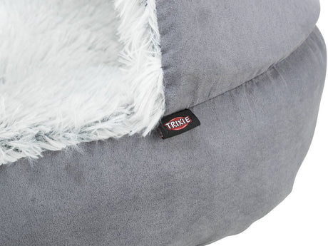 Graues, plüschiges Bett mit einem weißen, flauschigen Rand; Etikett mit der Aufschrift "Trixie".