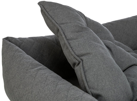 Graues, gepolstertes Sofabett mit klappbaren Armlehnen, aus gestepptem Stoff, Nahaufnahme des Gewebes.