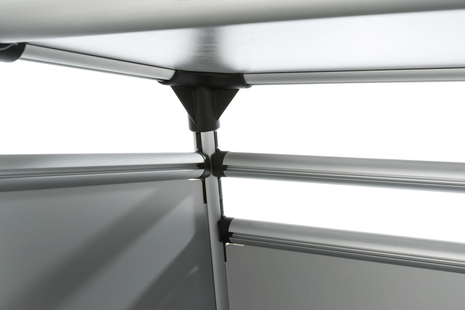 Metallene, silberne Struktur aus Rohren und Verbindungsstücken, die ineinander gesteckt sind, vor weißem Hintergrund.