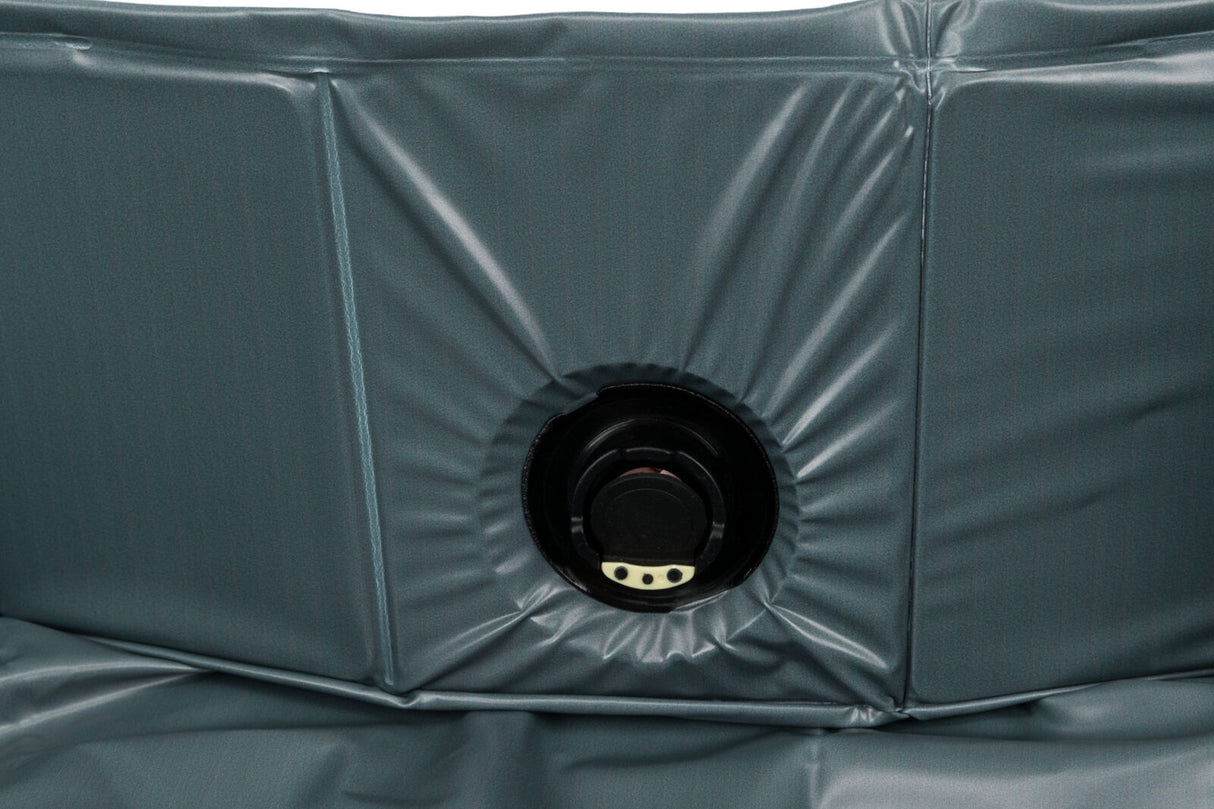 Graue Oberfläche mit elastischen Falten und einem schwarzen, runden Ventil in der Mitte, detailreich abgebildet.