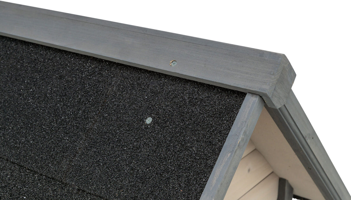Schwarzes, grobkörniges Dachmaterial mit grau gestrichenem Holzrahmen, Detailaufnahme einer Konstruktionsektion.