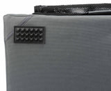 Graues Textilmaterial mit rechteckigem, genopptem, schwarzen Aufnäher und schwarzer Netztasche oben.
