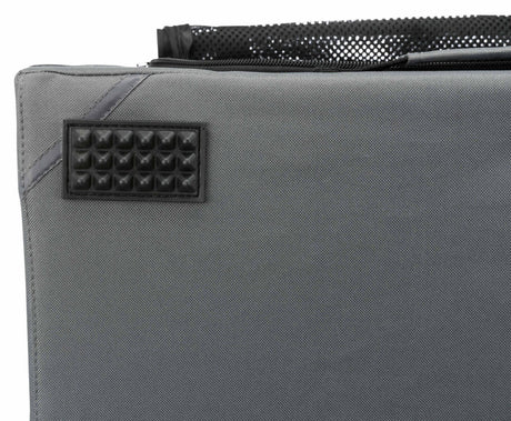 Graues Textilmaterial mit rechteckigem, genopptem, schwarzen Aufnäher und schwarzer Netztasche oben.