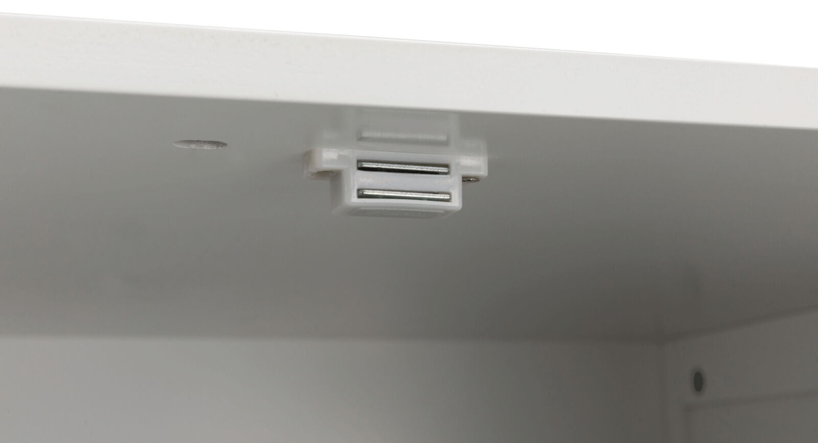 Weiße magnetische Schrankverriegelung an der Innenkante eines weißen Schrankes montiert.
