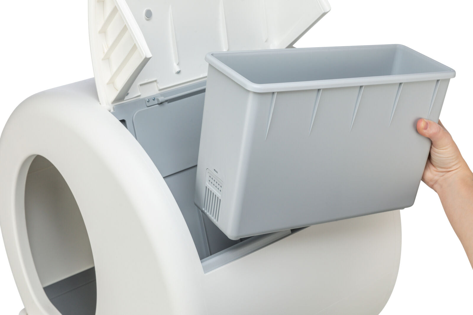 Eine Hand hebt einen rechteckigen grauen Behälter aus einer größeren weißen Vorrichtung mit offener Klappe.