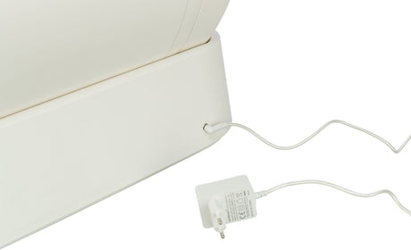 Ein weißes elektrisches Gerät ist mit einem Netzkabel verbunden, das in eine Steckdose eingesteckt wird.