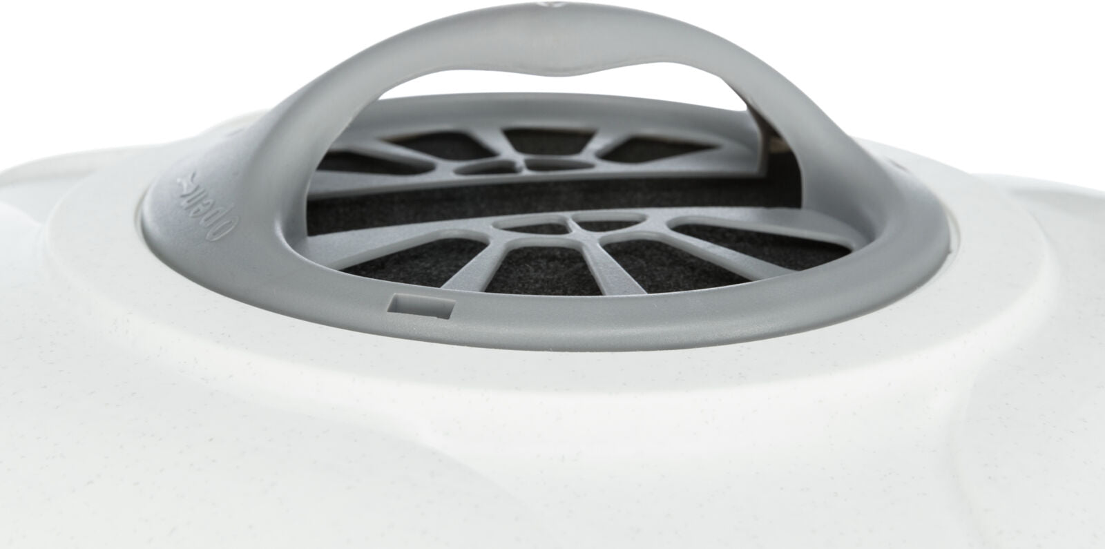 Grauer Kunststoffgriff auf weißer Oberfläche mit runden Lüftungsöffnungen und dunkelgrauem Gitter darunter.