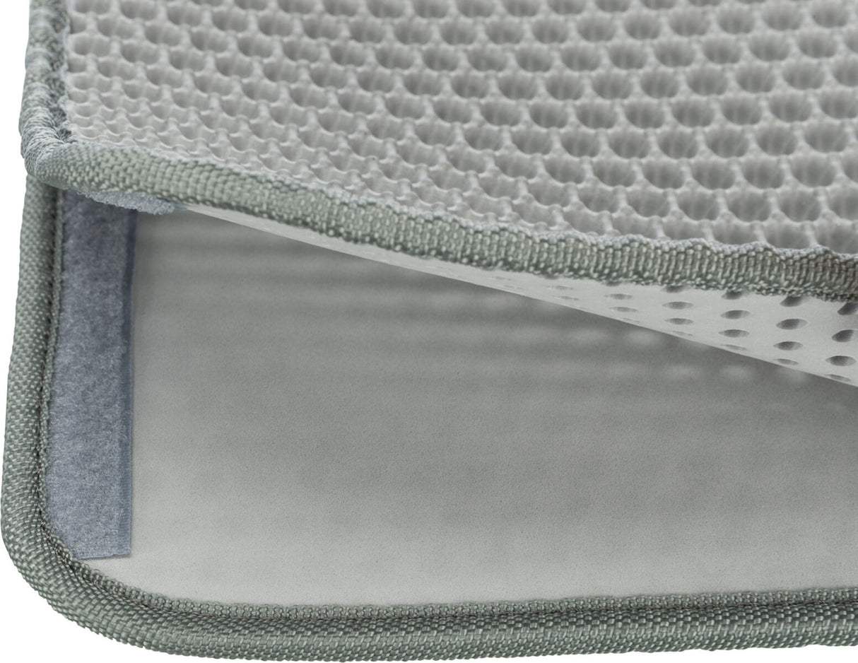 Graue rechteckige Matte mit wabenförmiger Textur und grüner Umrandung, teilweise zur Seite gefaltet.