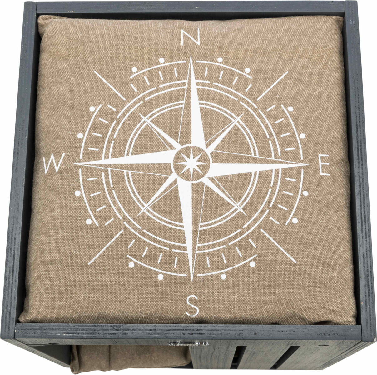 Kompassdesign in Weiß auf beigem Stoff in einer grauen Holzkiste, Himmelsrichtungen N, E, S, W markiert.