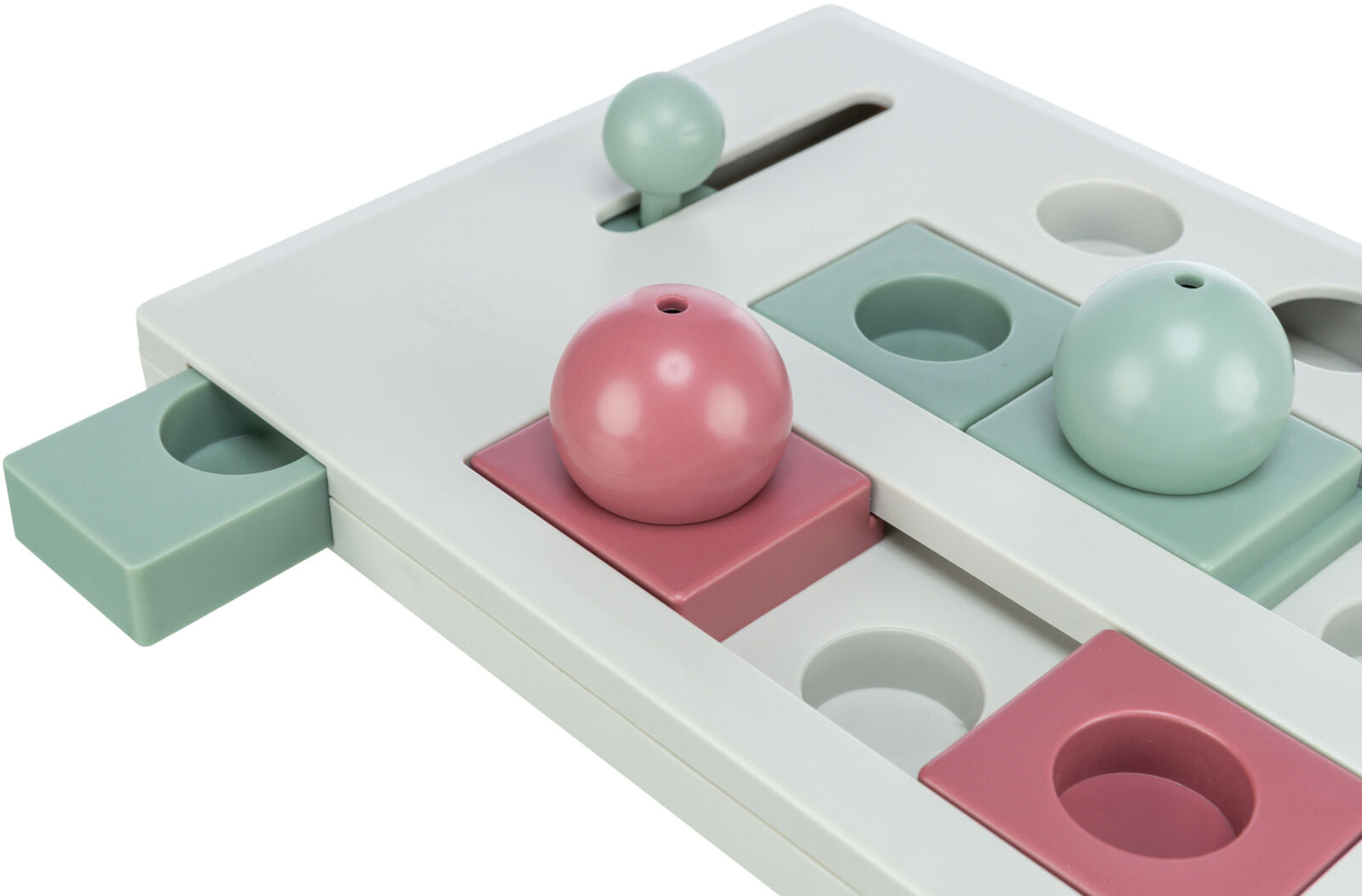 Spielzeug in Form eines Puzzles mit runden und quadratischen Elementen in Rosa und Grün auf weißer Basis.