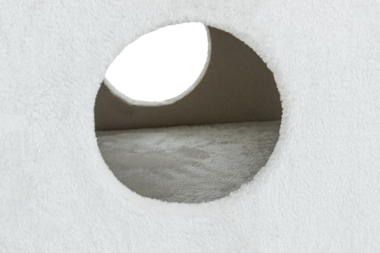 Weiße, flauschige Oberfläche mit runden Öffnungen, die einen Blick ins Innere ermöglichen, erkennbar.