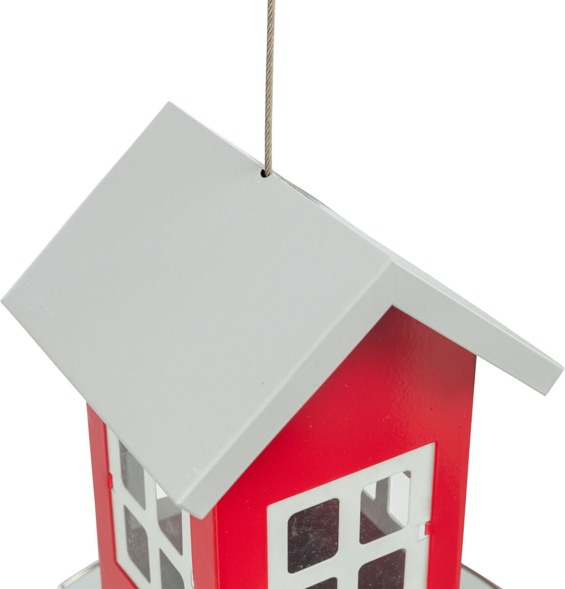 Rotes Vogelhaus mit weißem Satteldach, an Drahtseil aufgehängt, zeigt rechteckige Fensteröffnungen.