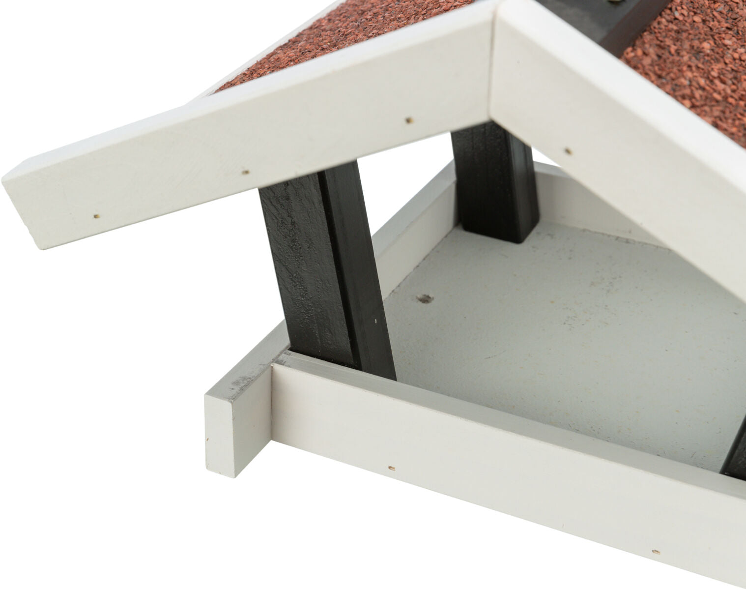 Holzhaus mit schwarzem Rahmen und weißer Basis, Dach mit roten Schindeln, teilweise sichtbar.