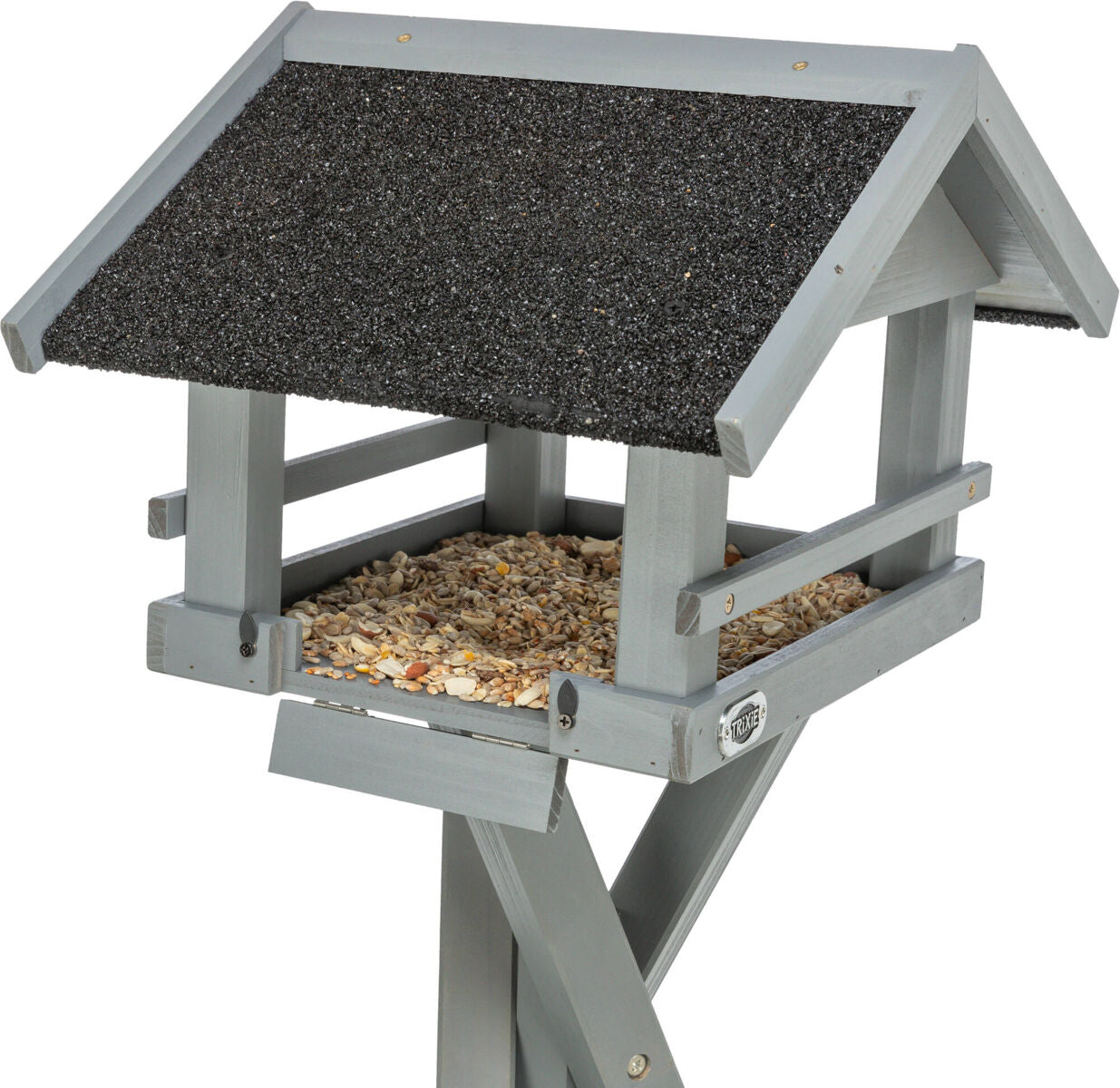 Graues Vogelhaus aus Holz mit schwarzem Dach, gefüllt mit verschiedenen Samen, steht auf einem einfachen Holzgestell.