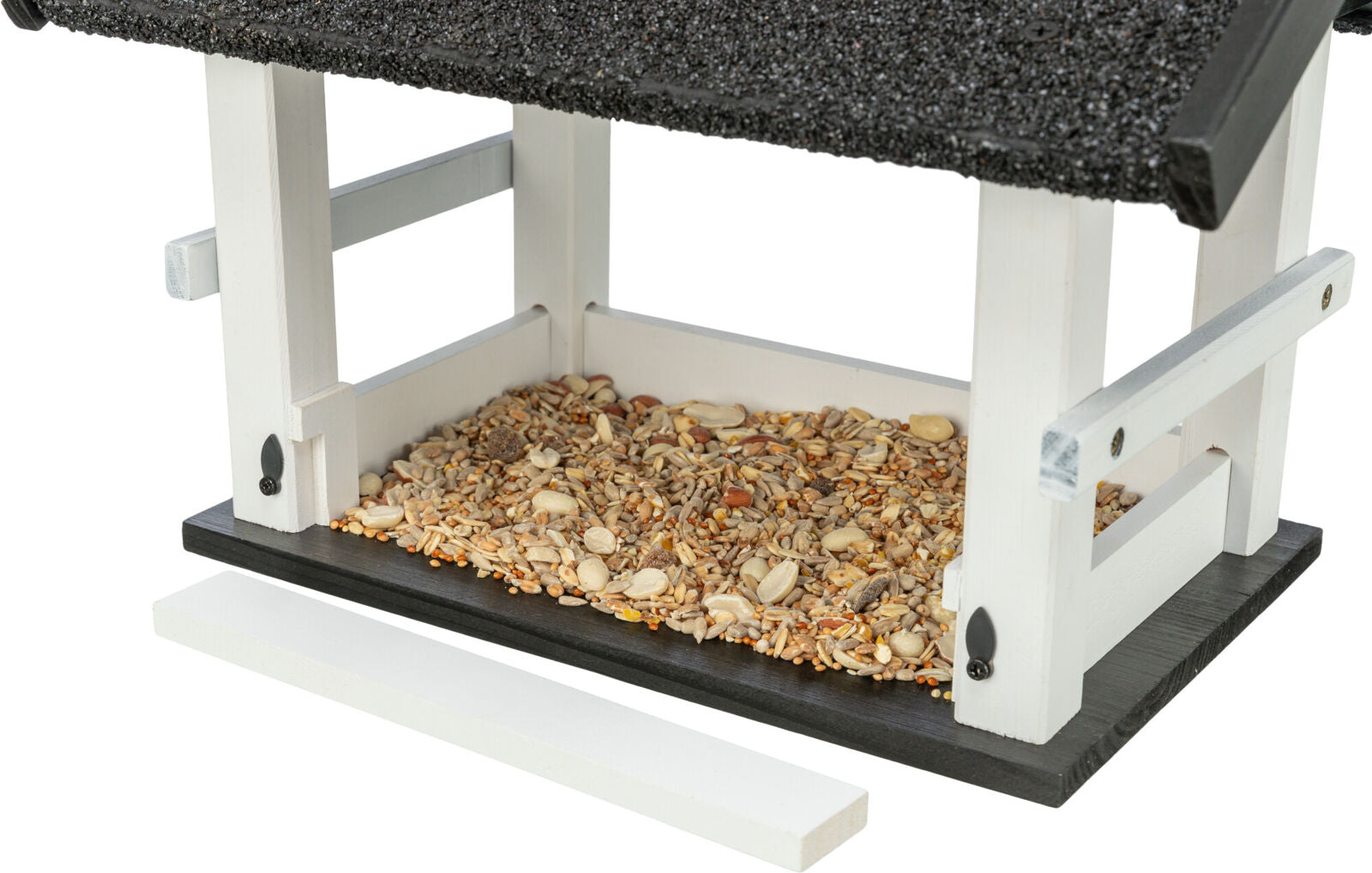 Ein weiß-graues Vogelhaus mit schwarzem Dach, gefüllt mit verschiedenen Körnern und Nüssen.