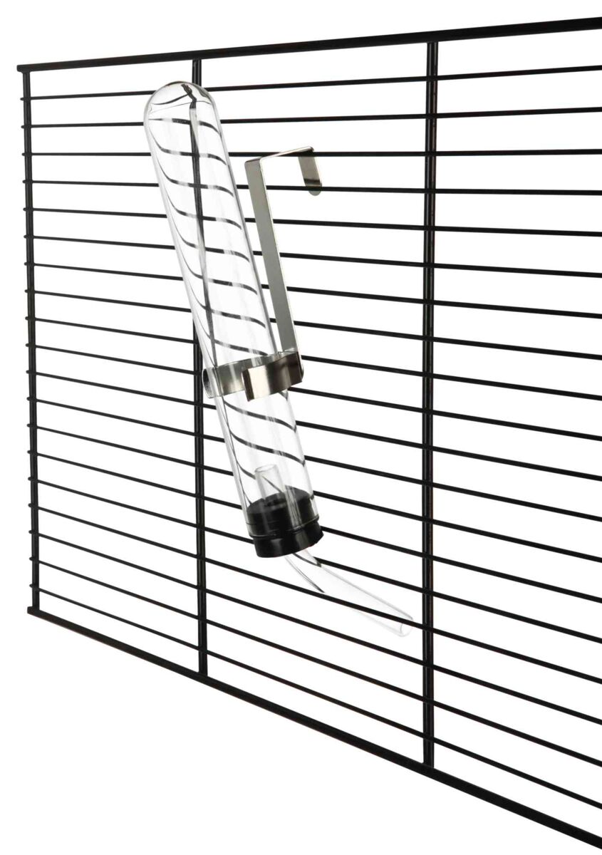 Ein transparentes Trinkfläschchen mit Metallhalterung ist an einem schwarzen Gitter befestigt.