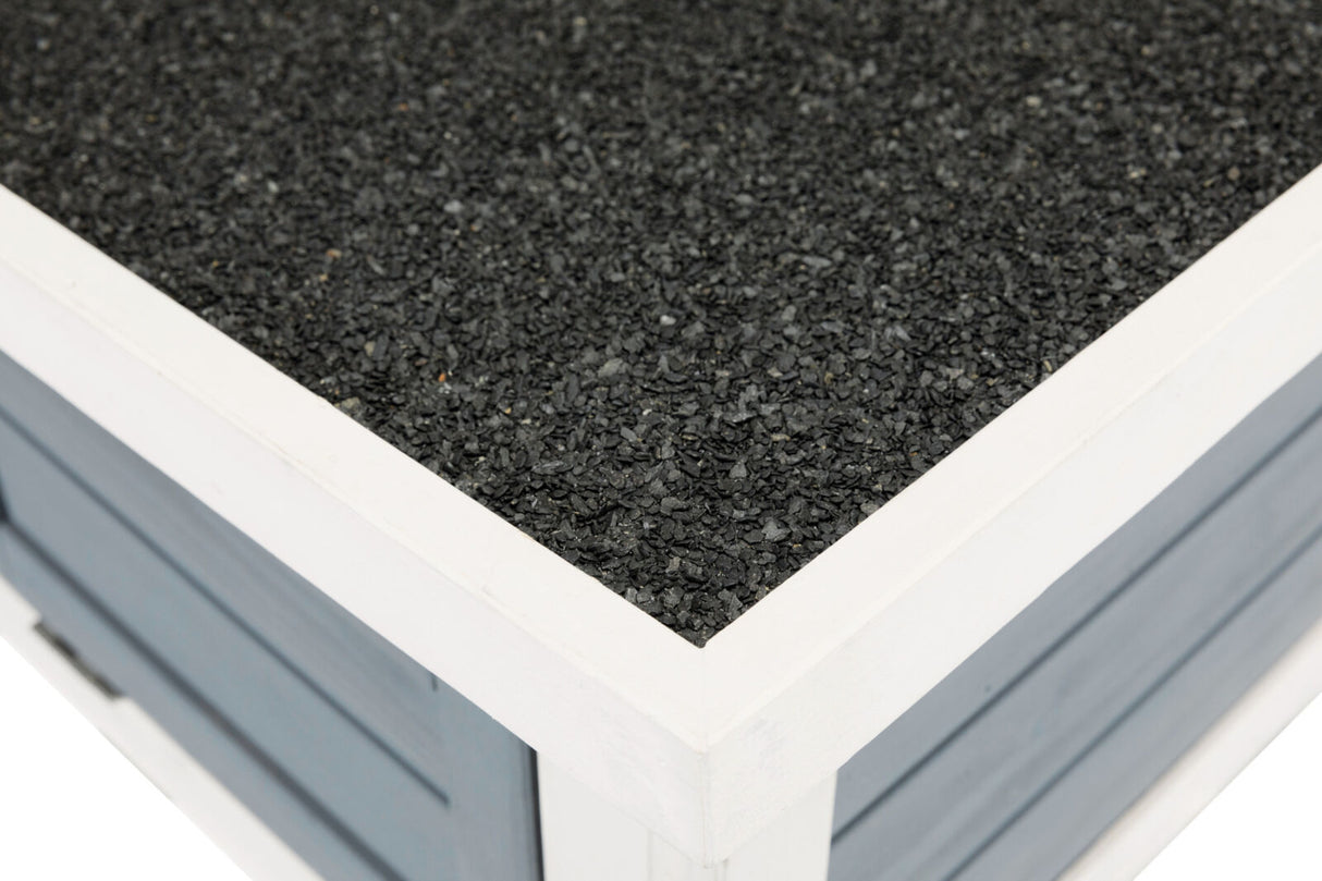 Nahaufnahme einer Oberflächenecke aus grobem, schwarzem Material mit einem weißen Rahmen auf blauer Struktur.