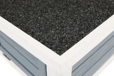 Nahaufnahme einer Oberflächenecke aus grobem, schwarzem Material mit einem weißen Rahmen auf blauer Struktur.
