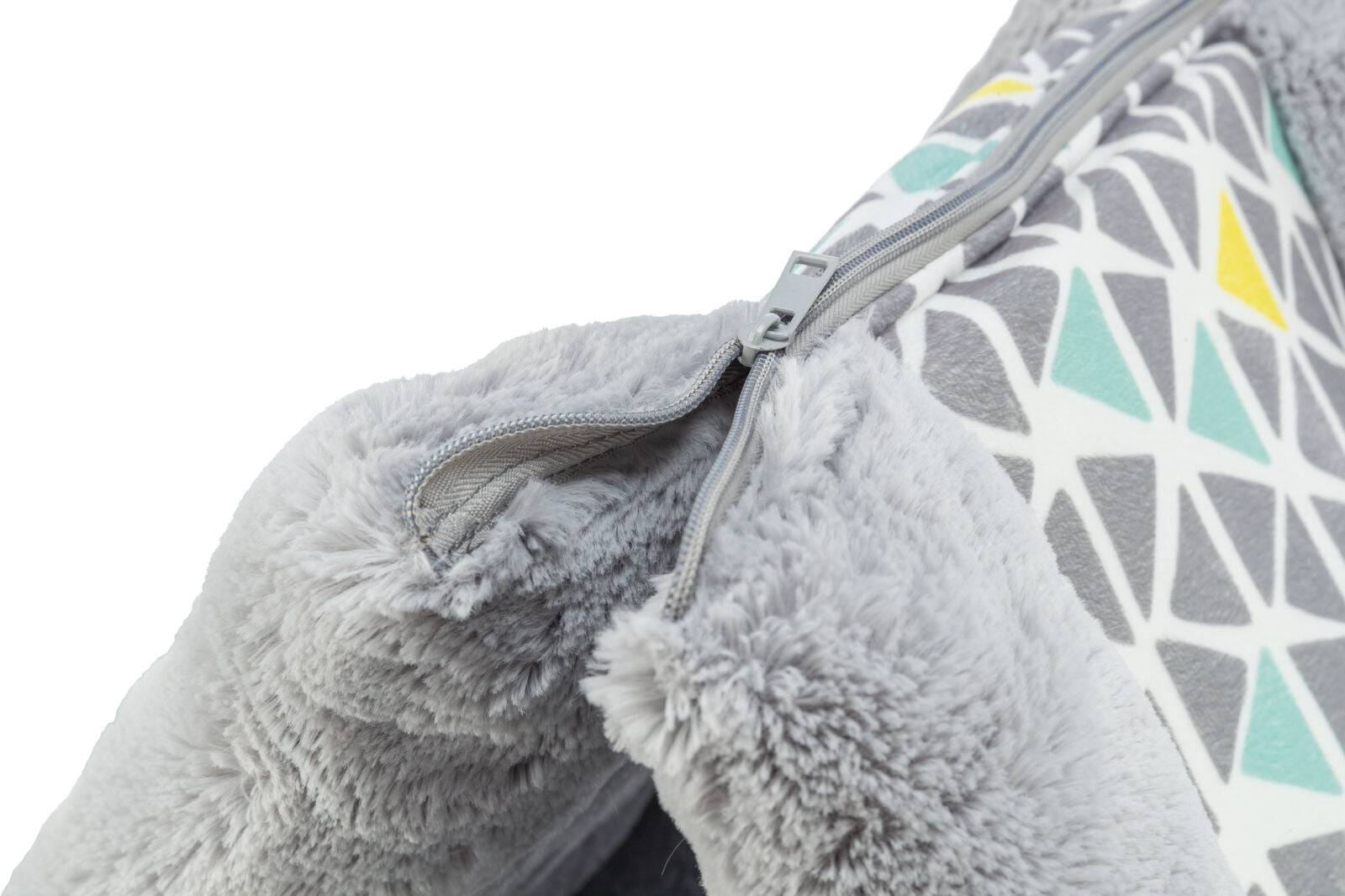 Grauer Plüschstoff mit geometrischem Muster in Gelb, Blau und Grau, teilweise verdeckt von einem Reißverschluss.