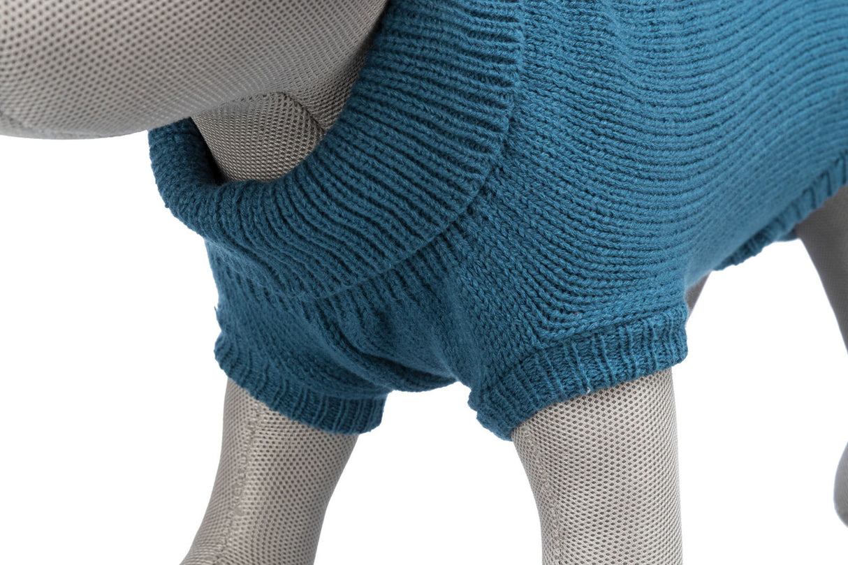 Grauer Puppenhund mit blauem gestrickten Hundemantel, deutlich sichtbar aus strukturiertem Stoff.