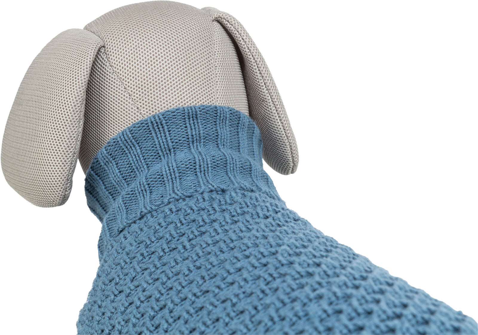 Stofftier in heller Farbe trägt einen blauen Strickpullover mit grober Textur und einem gerippten Kragen.