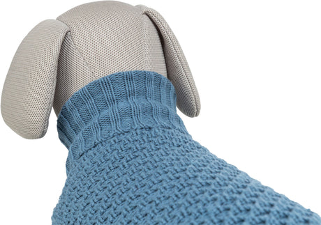 Stofftier in heller Farbe trägt einen blauen Strickpullover mit grober Textur und einem gerippten Kragen.