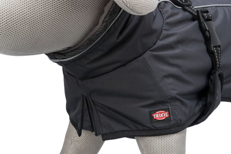 Grauer Hundemantel auf einer Stoffpuppe mit schwarzem Verschluss und rotem Logo, bestehend aus glattem Material.