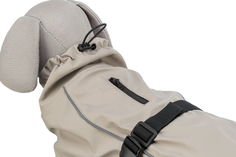 Beigefarbener Hundemantel mit schwarzem Reißverschluss und verstellbarem Gurt an einem Hundefigurenmodell.