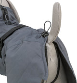 Grauer Hundemantel mit schwarzem Verschluss und elastischen Kordeln, über einem beigen Stoffmodell platziert.