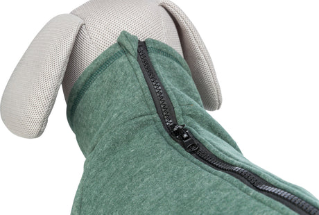 Beige Stofffigur trägt dunkelgrünen Hundemantel mit schwarzem Reißverschluss auf dem Rücken.