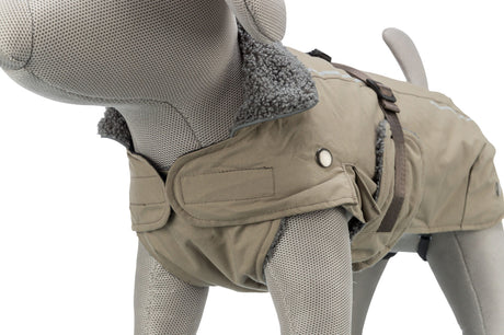 Grauer Hundemantel auf einem Stoffmodell mit flauschigem Kragen, Taschen und Schnallen in Beige und Braun.