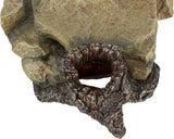 Steinfigur in erdigen Tönen mit runder Öffnung, die wie eine natürliche Höhle wirkt.