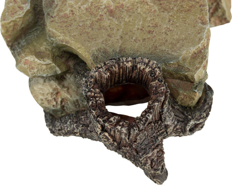 Steinfigur in erdigen Tönen mit runder Öffnung, die wie eine natürliche Höhle wirkt.
