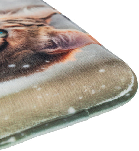 Weiches Kissen mit verschwommenem Katzendruck in Braun- und Beigetönen, Schneeflockenmotiv im Hintergrund.