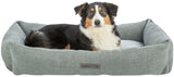 Ein schwarz-weiß-brauner Hund liegt in einem rechteckigen, grauen Hundebett mit Textlabel auf der Vorderseite.