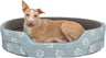 Ein hellbrauner Hund liegt in einem grauen Hundebett mit weißen und blauen Pfotenabdrücken.