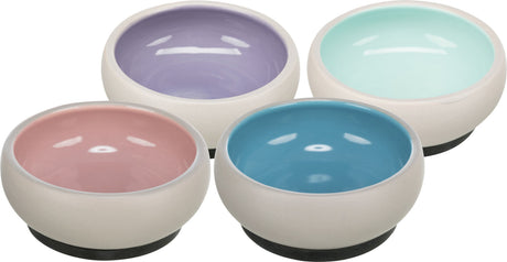 Vier runde Schalen auf schwarzem Sockel in Pastellfarben: lila, pink, blau und mintgrün, mit glatter Oberfläche.