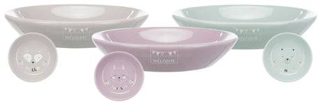Drei runde Schalen in Pastellfarben mit "WELCOME" Schriftzug, kleinere Teller mit Tiergesichtern und Worten "HELLO", "THIRSTY", "HUNGRY".